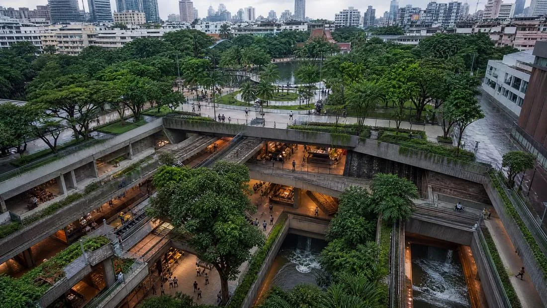 Vue aérienne d'une place urbaine en creux ouverte sur la skyline de Bangkok